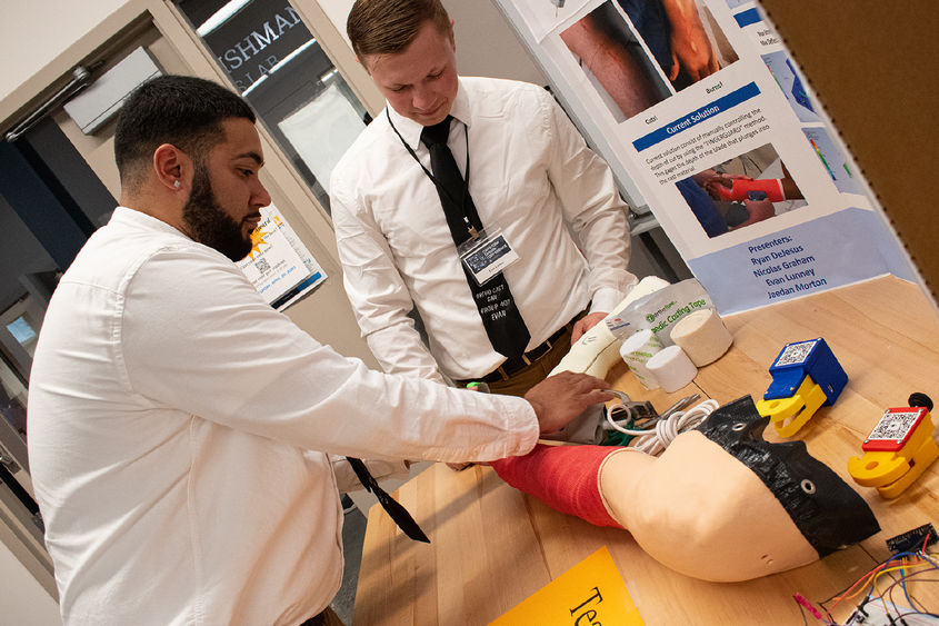 two male students demonstrating a cast removal project