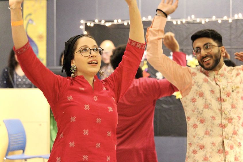 Two students dance at a Holi celebration