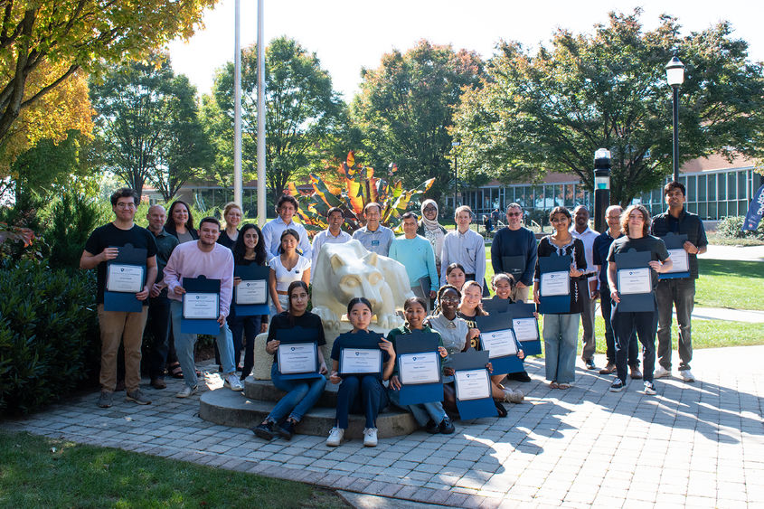 Group photo of REU award participants by the Nittany Lion statue