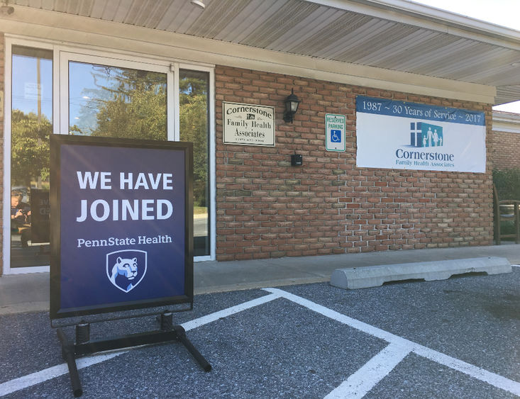 A sign reading "We have joined Penn State Health" sits in front of a brick building labeled "Cornerstone Family Health Associates."