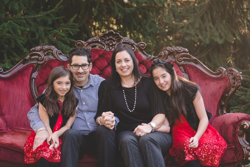 A family of four smiles for a photo.