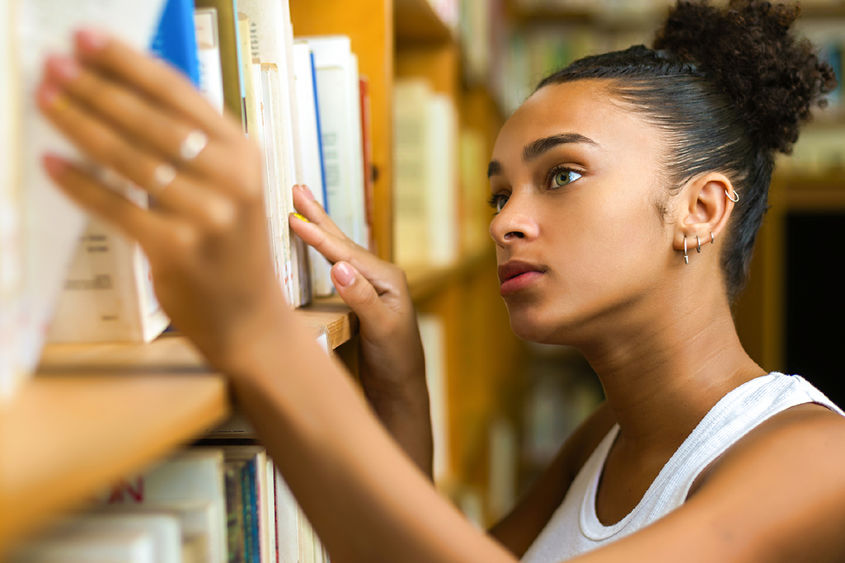 female looking at books on shelf