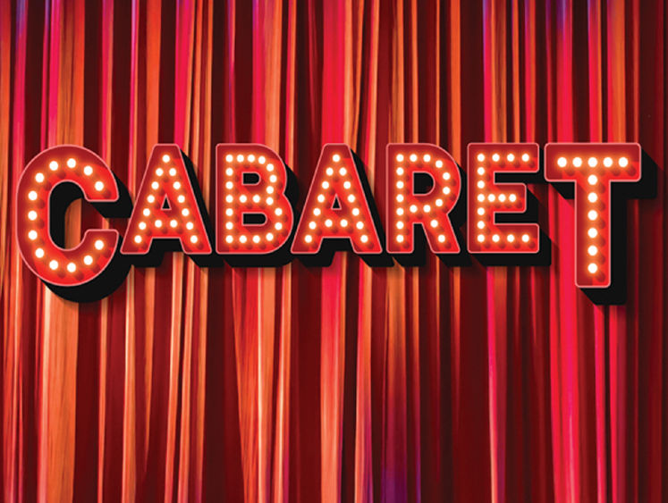 Red marquee letters spelling the word Cabaret in front of a red pleated stage curtain