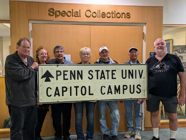 7 Penn State Harrisburg alums and family members pose with a sign that says Penn State Univ. Capitol Campus