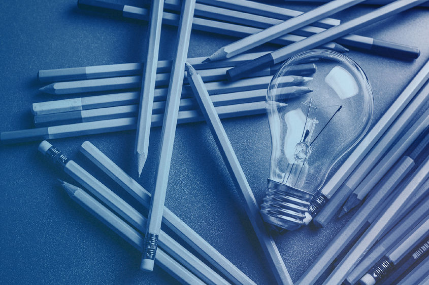 lightbulb with scattered pencils