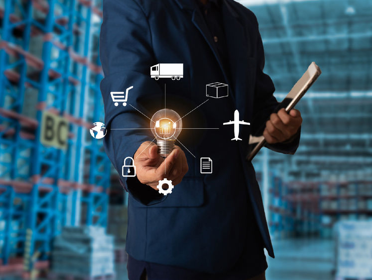 Man in suit holding tablet and lightbulb 