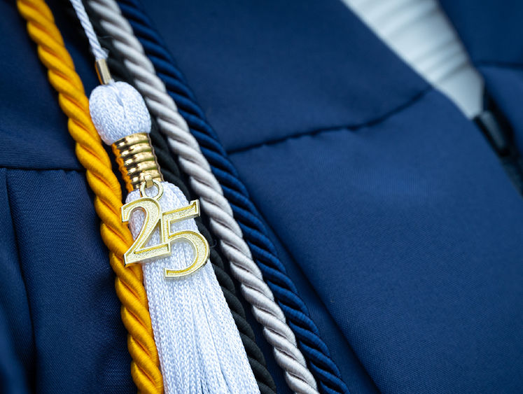 Closeup of a graduation tassel with a gold 25 attached