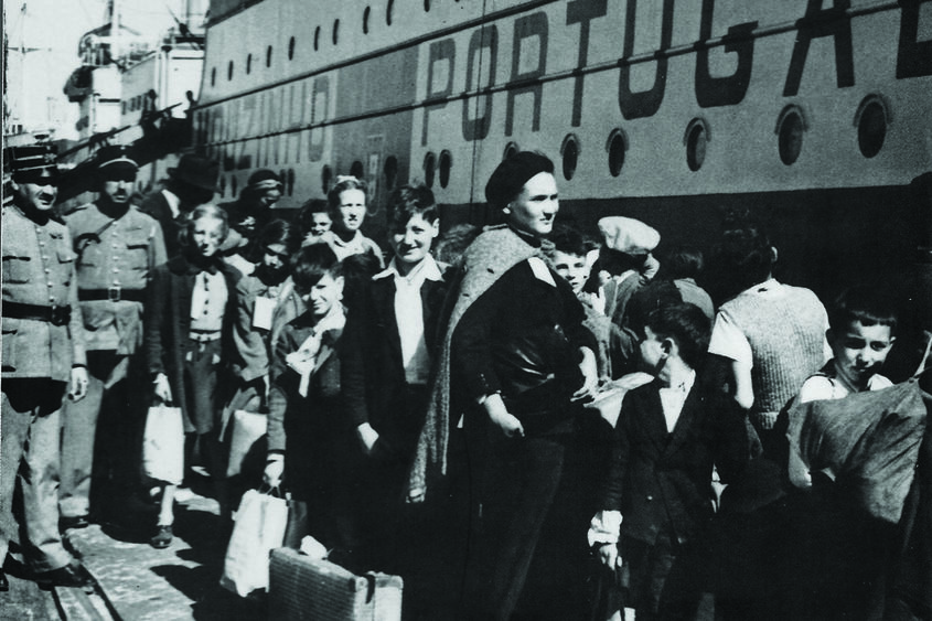 black and white photo of people waiting to board a boat