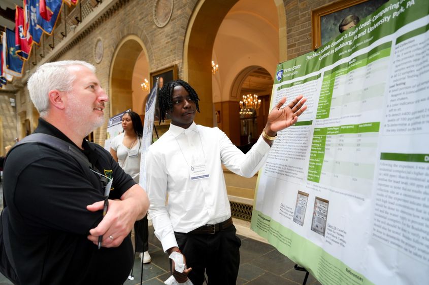 A student presents a scientific poster to a person