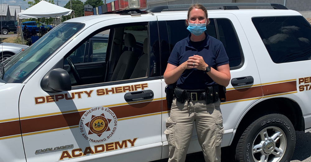 Sheriff deputy standing in front of training vehicle