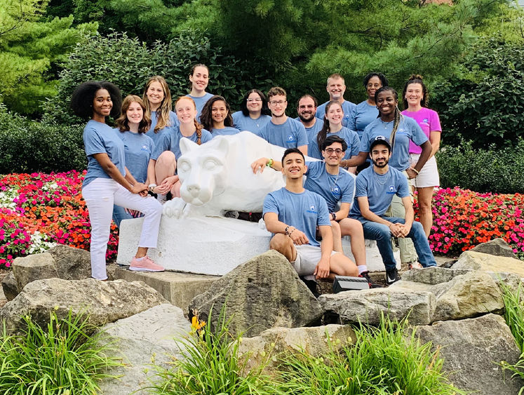 Group photo of students and staff members around Nittany Lion statue