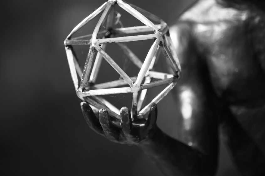 black and white image of sculpture hand and geometric figure