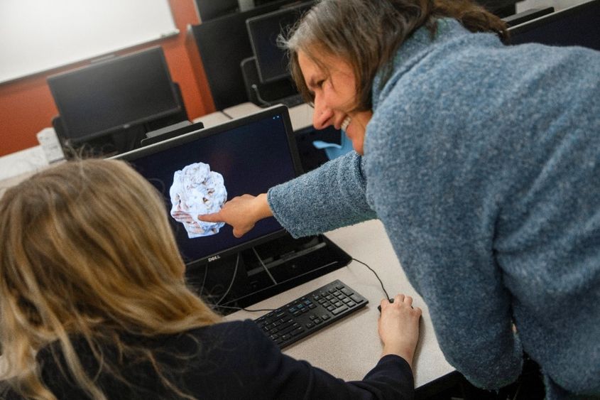 Instructor points at 3D rock on student's computer