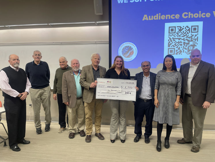 Erin Godfrey, winner of the Harrisburg LaunchBox Veterans Pitch Competition, holds a large check, surrounded by judges and others