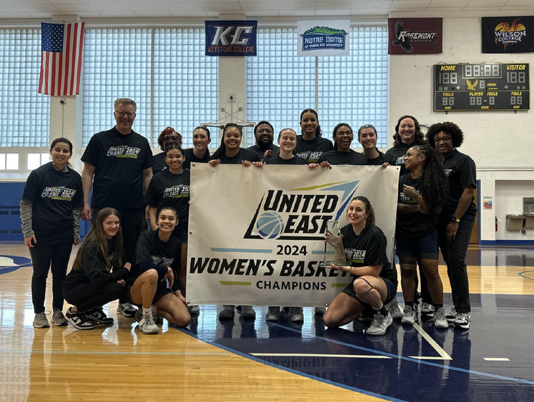 Penn State Harrisburg women's basketball team holding a banner that says United East 2024 Women's Basketball Champions
