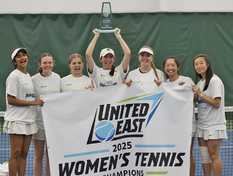 A group of women holding a banner that says United East 2025 women's tennis champions